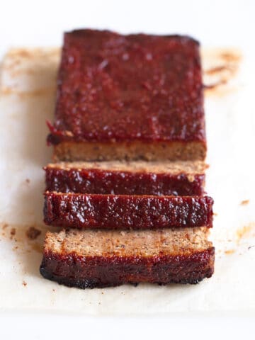 Foto de un pastel de carne vegano troceado sobre un fondo blanco
