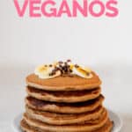 Foto de perfil de un plato pancakes veganos decorados con plátano y chips de chocolate con las palabras pancakes veganos
