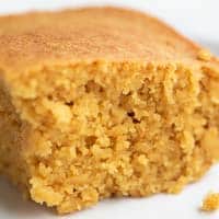 Foto cuadrada de cerca de un trozo de pan de maíz vegano en un plato