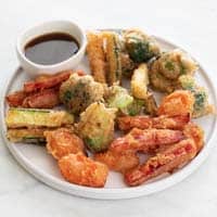 Foto pequeña de un plato con verduras en tempura y salsa de soja