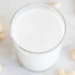 Foto cuadrada de un vaso con leche de anacardos casera