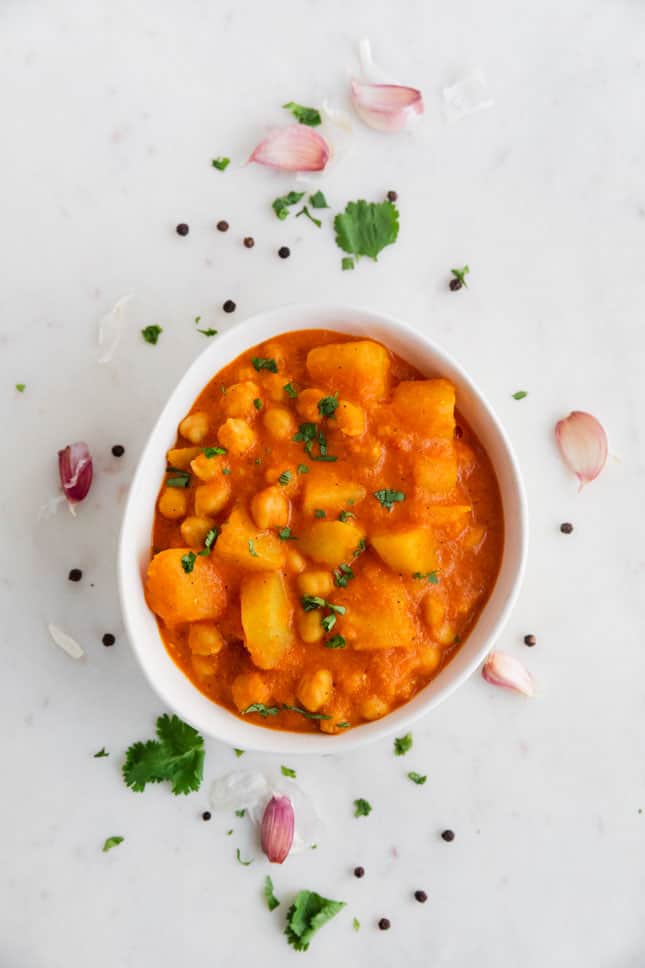 Foto desde arriba de un bol de curry vegano decorado con perejil
