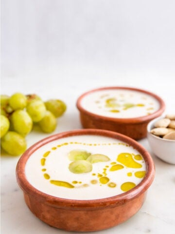 Foto de 2 bols de ajoblanco con decoración de uvas y aceite de oliva