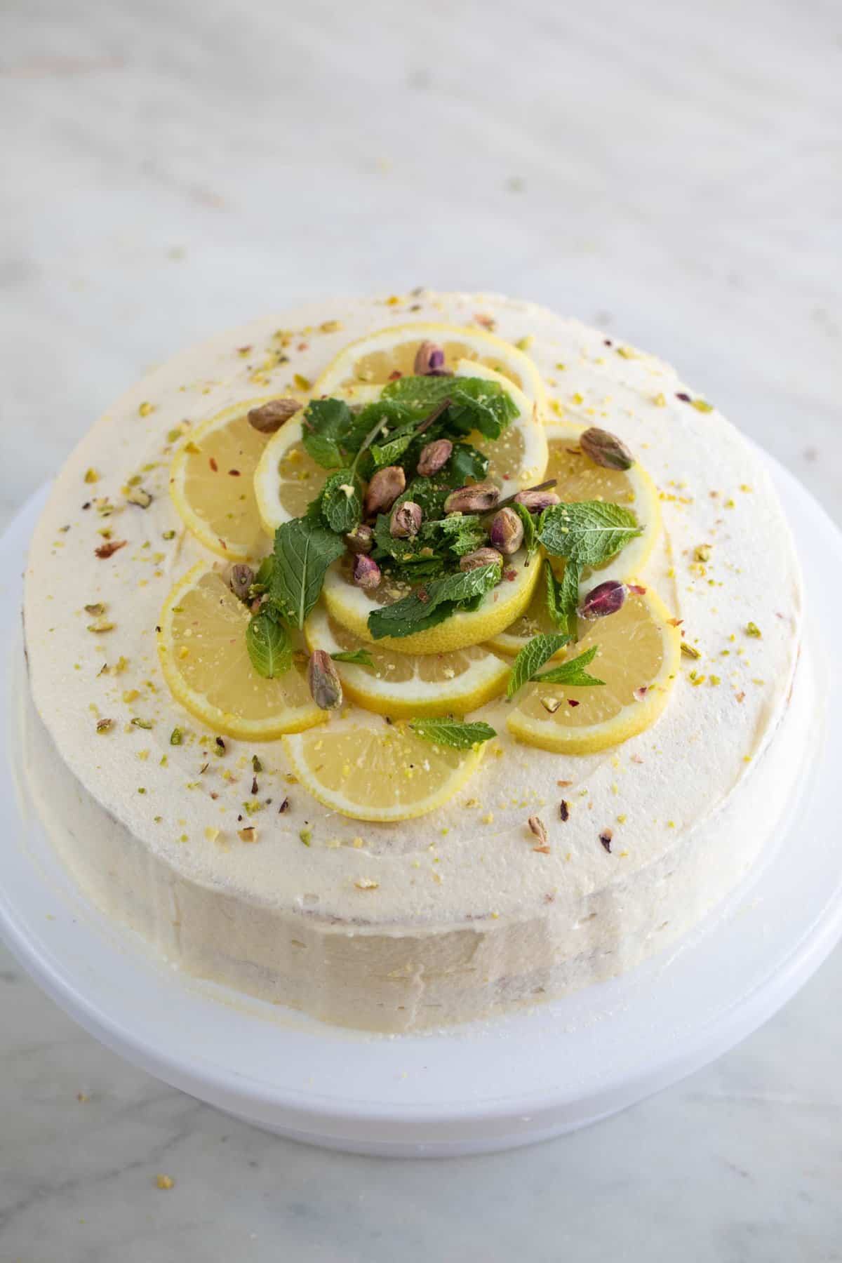 Tarta de limón vegana encima de una base para tartas.