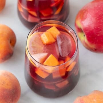 Vasos de sangría con fresca fruta a su alrededor.
