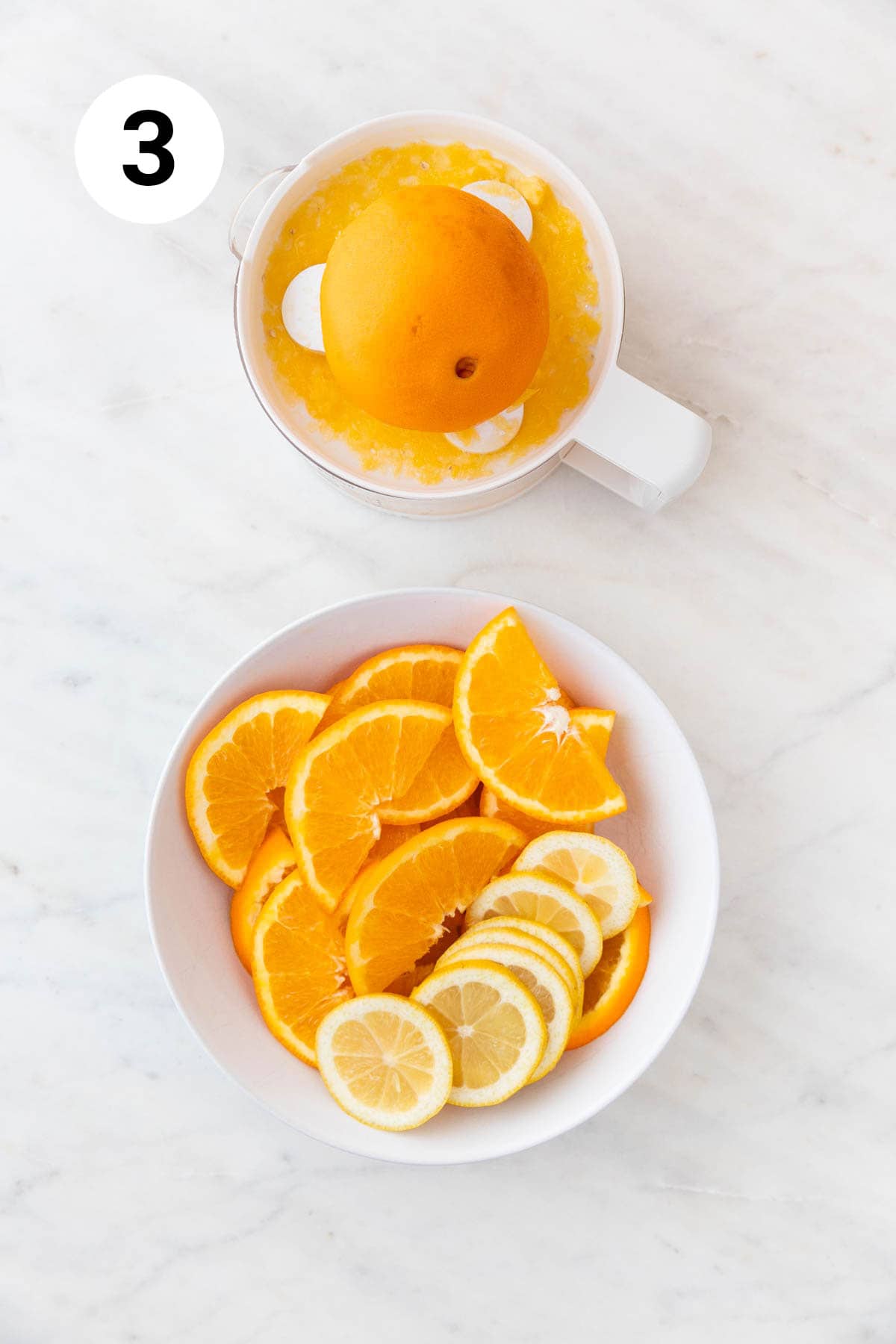Plato con naranja y limón en rodajas y exprimidor de naranjas con zumo de naranja.