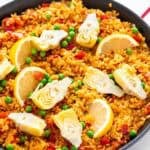 Paella de verduras con gajos de limón por encima.