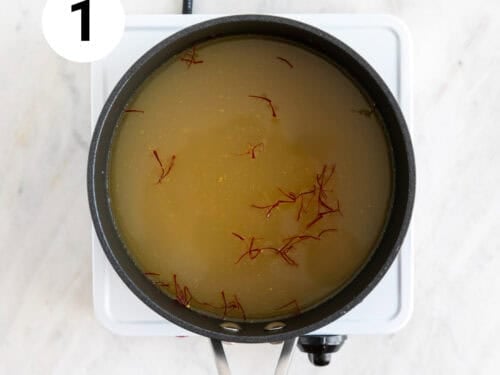 Cazo con caldo de verduras y azafrán.