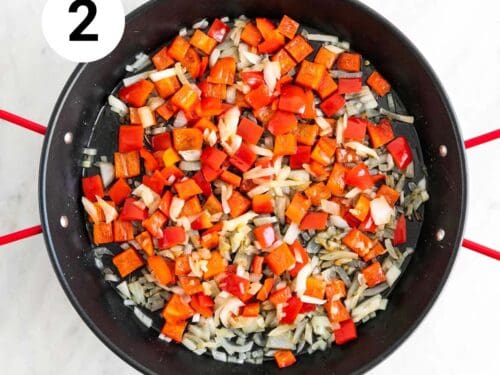 Cebolla y pimiento rojo sofritos en una paellera.