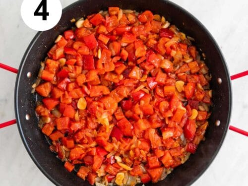 Verduras, tomate y pimentón cocinados en una paellera.