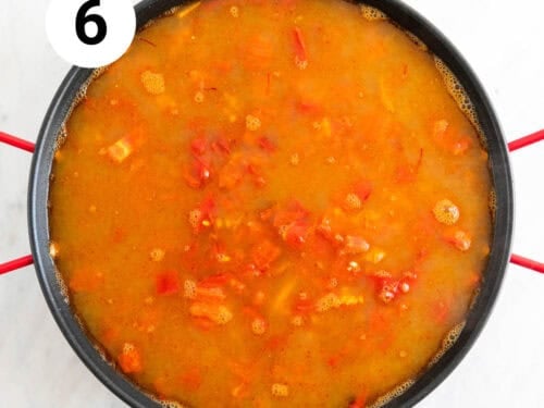 Verduras, arroz y caldo en una paellera.