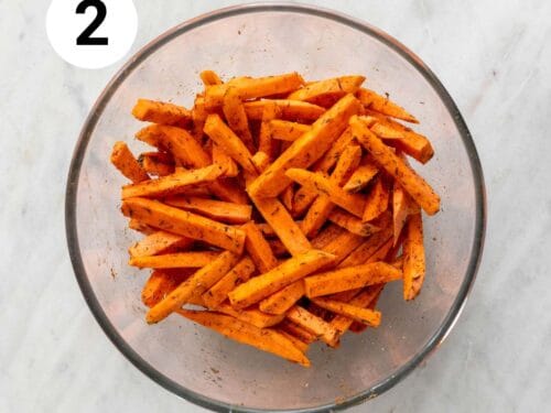 Bastones de boniato con aceite y especias en un bol.