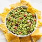 Bol de guacamole casero con nachos alrededor.