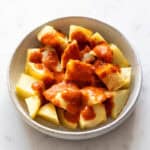 Patatas fritas con salsa brava en un plato.