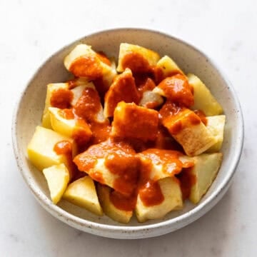 Patatas fritas con salsa brava en un plato.