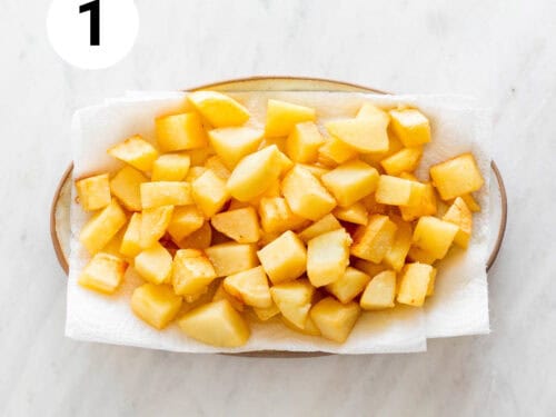 Patatas fritas sobre una bandeja con papel absorbente.