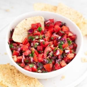 Salsa pico de gallo servida en un plato blanco con nachos.