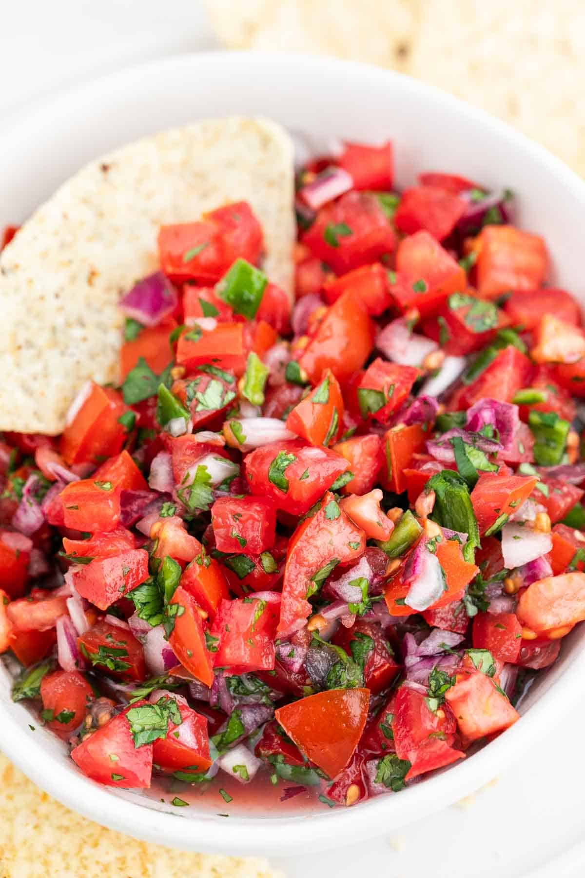 Pico de gallo en un bol con un nacho.