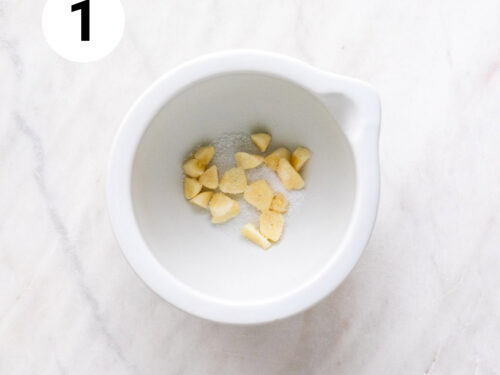 Ajos y sal en un mortero.