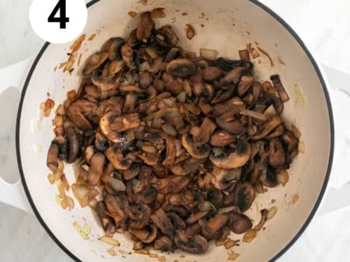 Champiñones, ajo y cebolla salteados en una olla después de haber echado el vino.