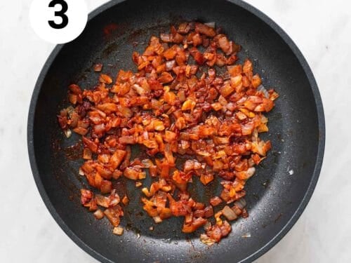 Ajo y cebolla salteados en una sartén con pimentón.