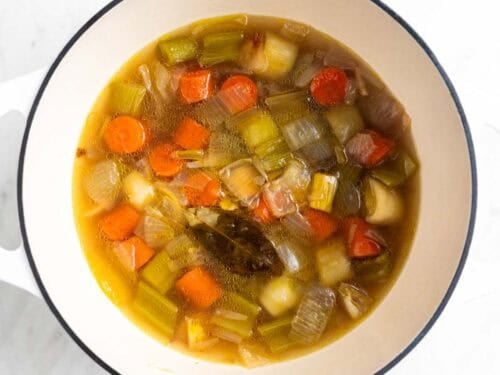 Caldo de verduras cocinado en una olla antes de colar las verduras.