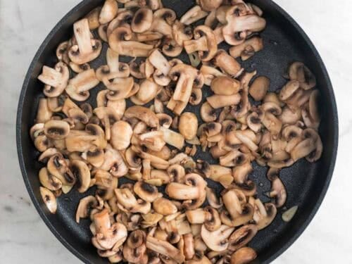 Champiñones salteados en una sartén.