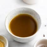 Salsa vinagreta en un bol con ingredientes alrededor.