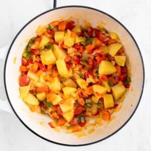 Verduras y patatas salteadas en una olla.