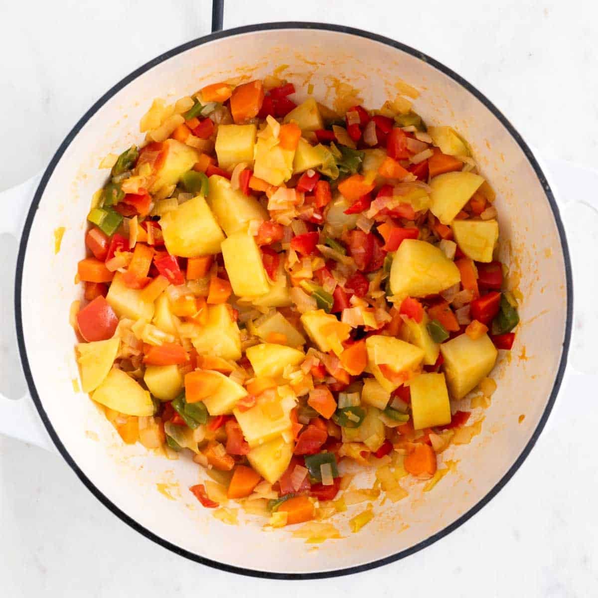 Verduras y patatas salteadas en una olla.