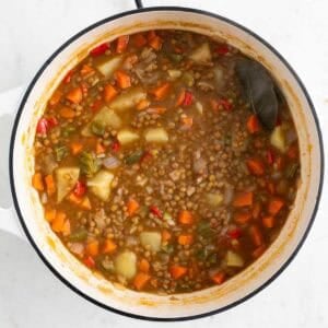 Lentejas con verduras en una olla.