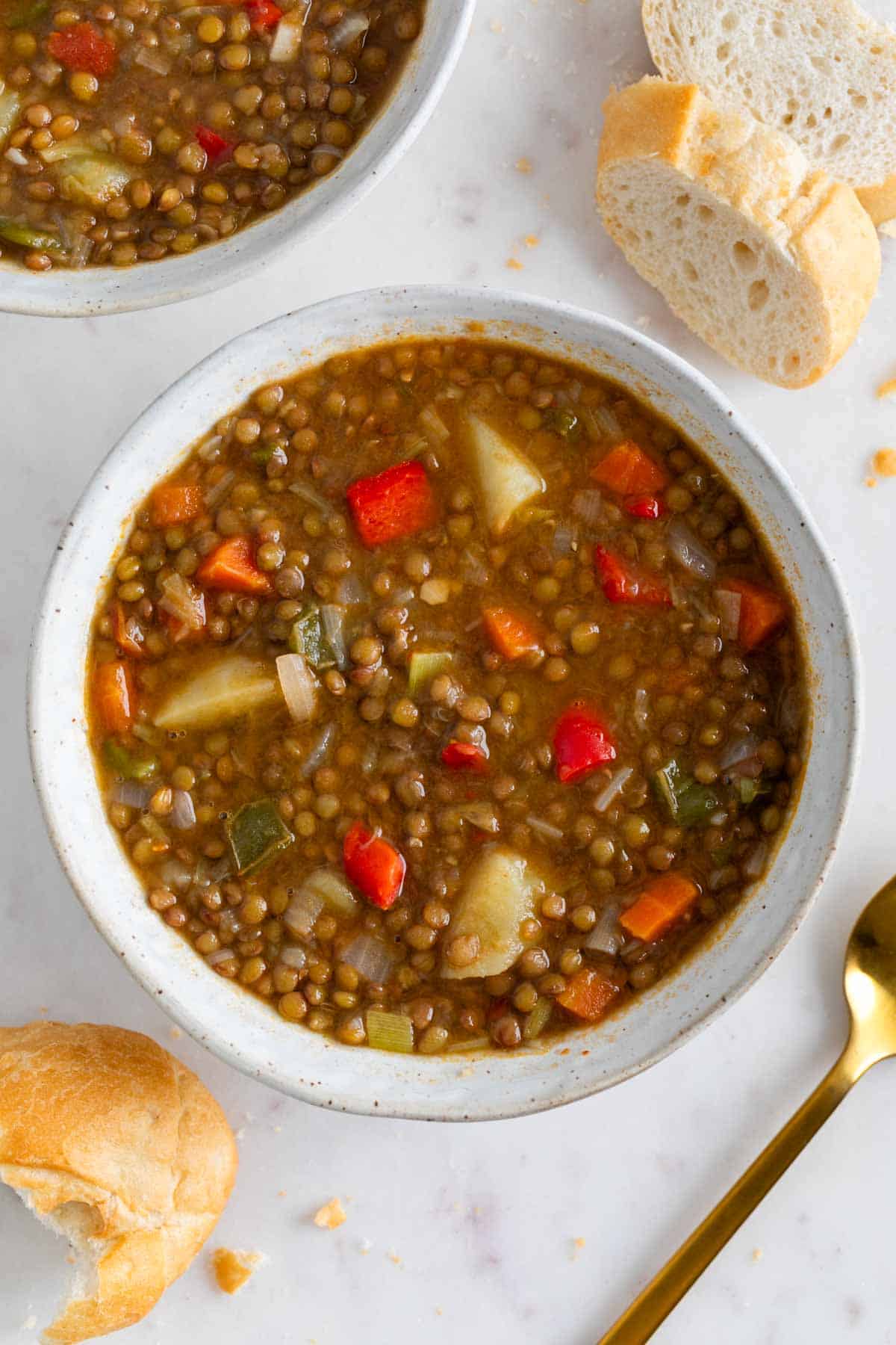 Boles de lentejas con verduras con pan de fondo.