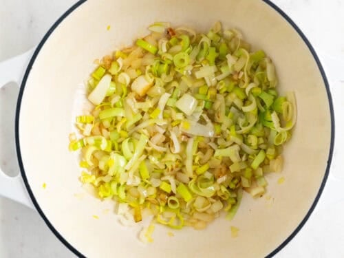Cebolla y puerro salteados en una olla.
