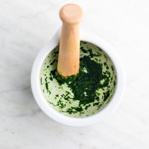 Ajo y perejil machacados en un mortero.