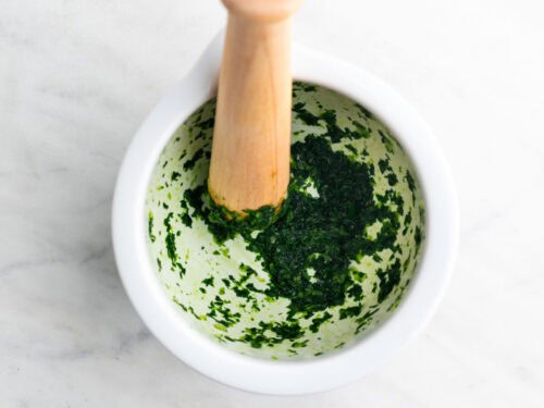 Ajo y perejil machacados en un mortero.