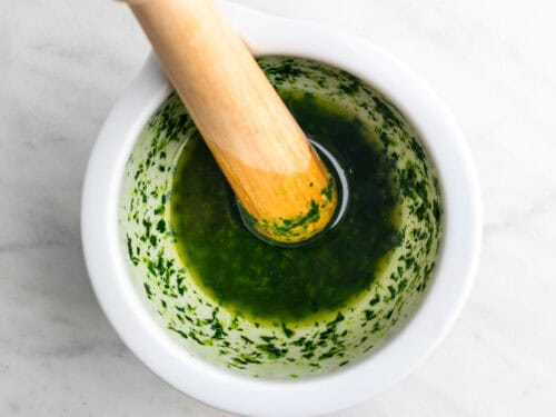 Salsa de ajo, perejil y aceite en un mortero.