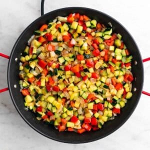 Verduras sofritas en una paellera.
