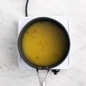 Caldo de verduras con azafrán en un cazo.