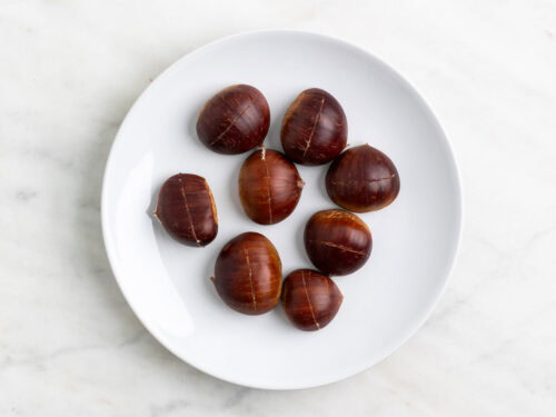 Castañas en un plato lista para asarse en el microondas.