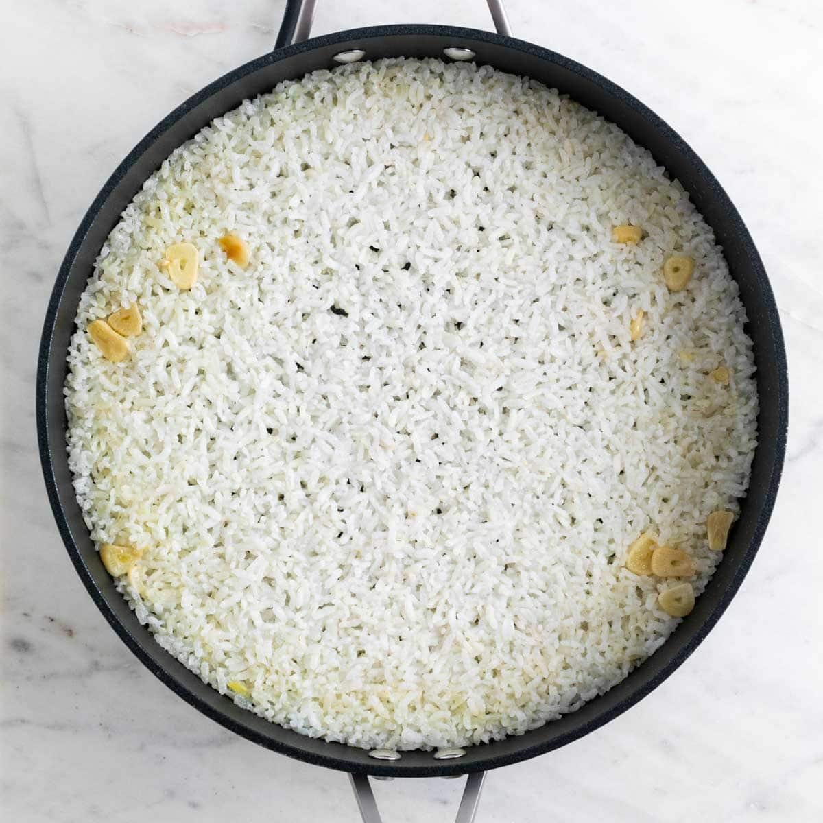 Arroz blanco cocinado en una sartén después de haber reposado.