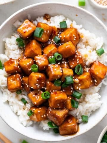 Plato con tofu a la naranja y arroz con semillas de sésamo y cebolleta.