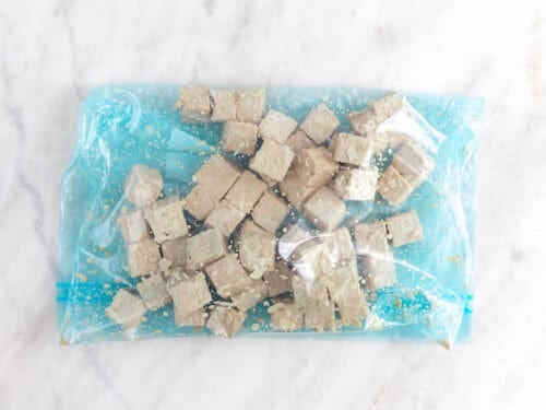 Dados de tofu rebozados en una bolsa de congelación.