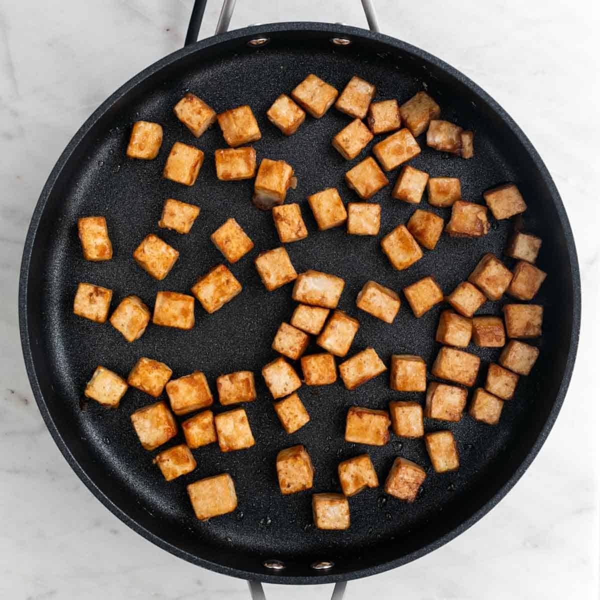 Tofu frito en la sartén.