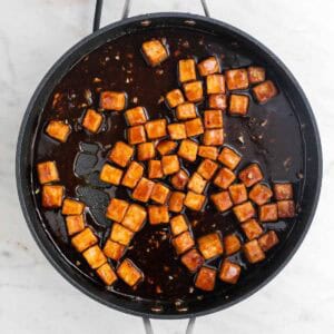 Tofu en una sartén cocinado con la salsa.