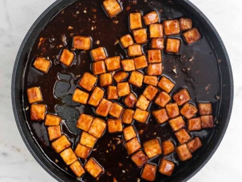 Tofu en una sartén cocinado con la salsa.