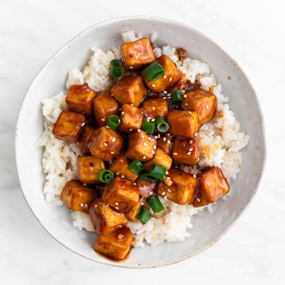 Tofu a la naranja sobre cama de arroz.