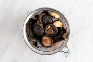 Colador con los ingredientes colados de la salsa de pescado vegana.