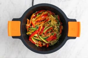 Verduras salteadas en una cazuela con ajo.