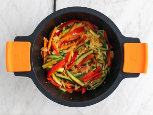 Verduras salteadas en una cazuela con ajo.