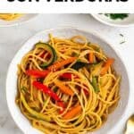 Espaguetis con verduras salteadas presentados en un bol, con un toque de sésamo y cebollino.